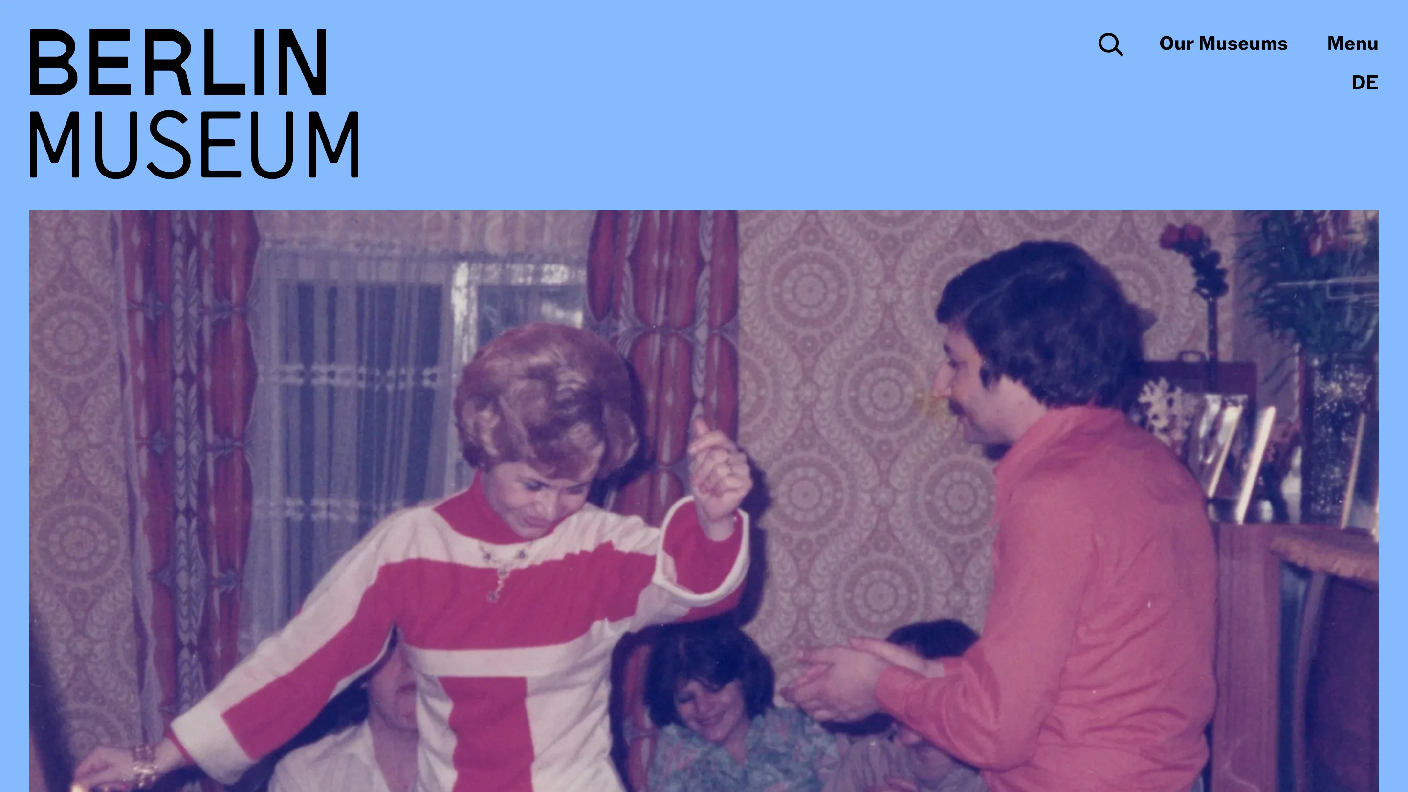 The Berlin Museum home page: a bold black BERLIN MUSEUM wordmark on a sky-blue field above a 1970s color photograph of people in a patterned living room